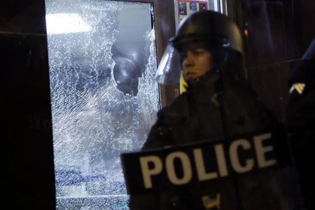 شرطي يقف أمام متجر متضرر خلال احتجاجات بولاية ميسوري عام 2014 (رويترز) 