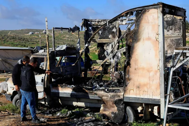  Palestinians check damage to a burned vehicle, which Palestinians say was damaged by Israeli settlers, in Susiya near Hebron in the Israeli-occupied West Bank February 25, 2026. (Reuters)