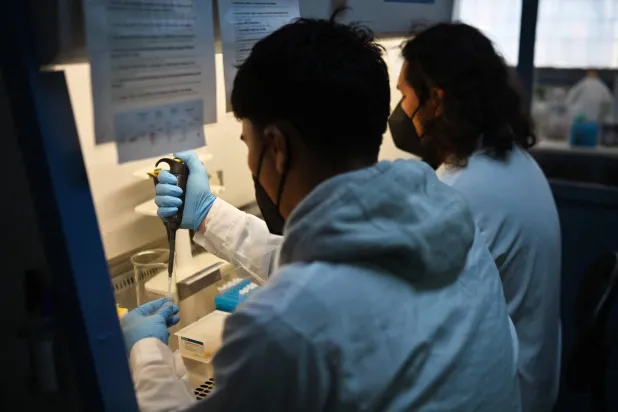 علماء يعملون في مختبرات تابعة لجامعة تشيلي في سانتياغو (أ.ف.ب)