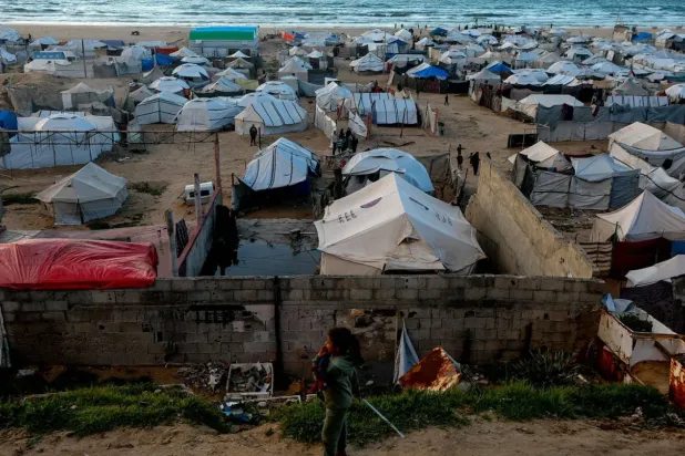Gazze Şehrindeki sahil yakınlarında geçici çadırların önünde duran yerinden edilmiş Filistinli bir kız çocuğu (EPA)