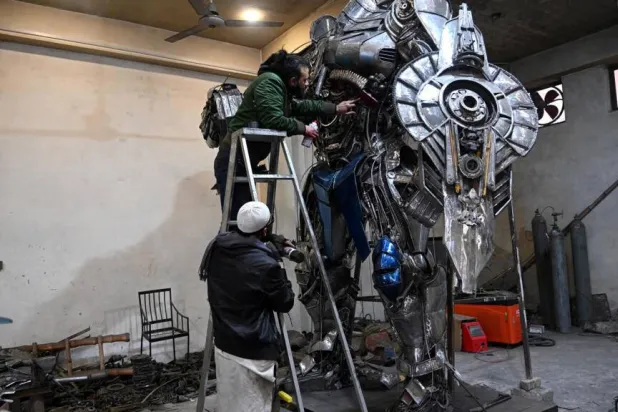 Sculptor Ehtisham Jadoon spray paints a model of Optimus Prime, a film character from Transformers, made from scrap metal at his studio. Farooq NAEEM / AFP
