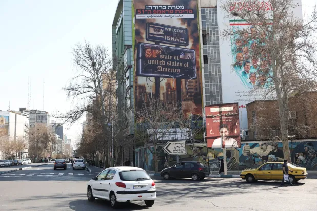 لوحة إعلانية معادية لإسرائيل والولايات المتحدة على مبنى في طهران (رويترز)
