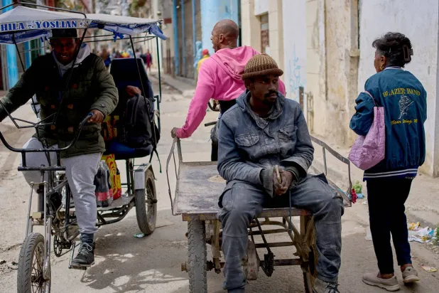  تعاني كوبا من ارتفاع كبير بمستويات الفقر... وفي الصورة أشخاص بأحد أحياء هافانا يوم 24 فبراير (أ.ب)