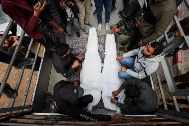 Filistinliler, dün Gazze'ye düzenlenen İsrail hava saldırısında öldürülen iki kişinin cesetlerinin yanında bekliyor (Reuters)