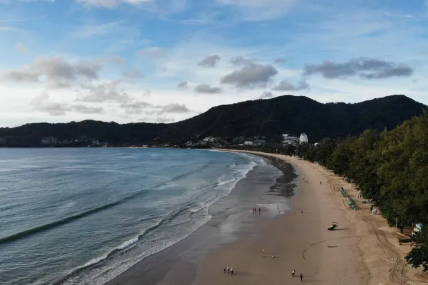 People walk along Patong Beach in Phuket, Thailand, June 29, 2021. (AFP)