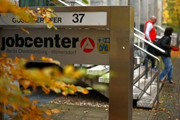 يمشي أشخاص خارج مركز توظيف في برلين (رويترز)
