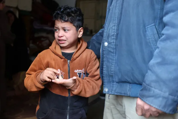 طفل فلسطيني خلال تشييع والده الشرطي الذي قُتل بغارة إسرائيلية في خان يونس الجمعة (رويترز)