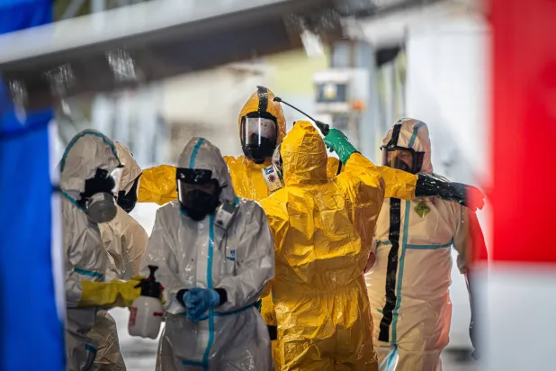 مجموعة من عناصر الإطفاء يغتسلون عقب التخلص من عدد كبير من الدجاجات المصابة بإنفلونزا الطيور في التشيك 23 فبراير 2023 (د.ب.أ)