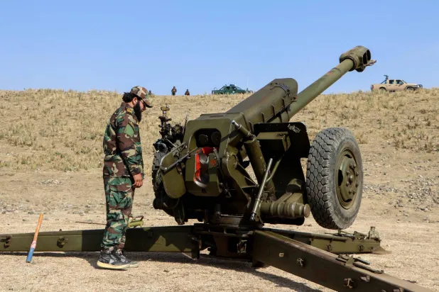 أفراد من قوات طالبان بجوار مدفع قرب منطقة حدودية مع باكستان (ا.ف.ب)