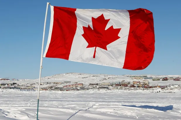علم كندا يظهر وسط ساحة مليئة بالثلوج (رويترز)