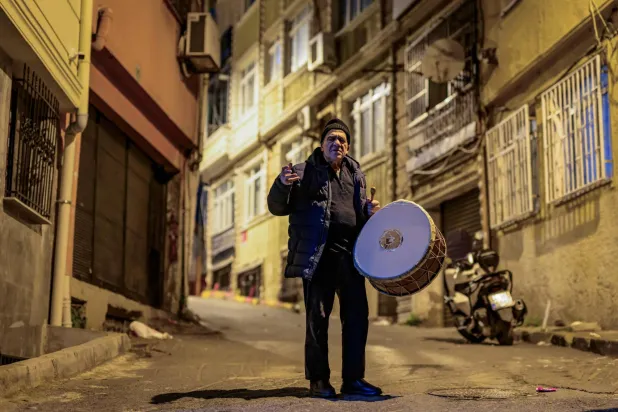 Turkish drummer Hakan Ozbingol plays drum and sings traditional songs in the streets of Istanbul, to wake Muslims up for the suhour, the Ramadan meal eaten at night, on February 24, 2026. (AFP) 