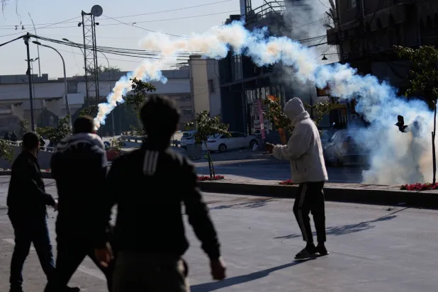 القوى الأمنية العراقية تطلق قنابل مسيلة للدموع على متظاهرين في المنطقة الخضراء (أ.ب)