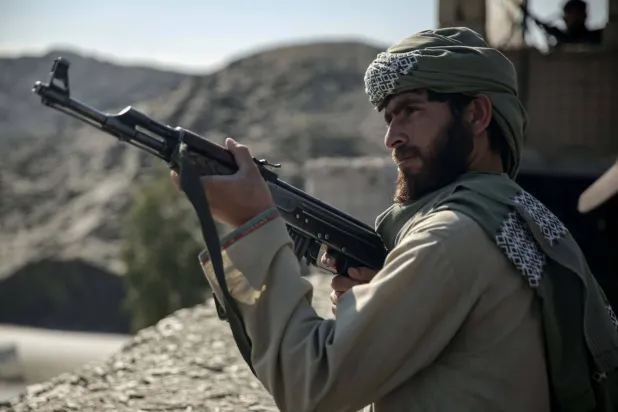 أحد عناصر حركة «طالبان» قرب معبر طورخم الحدودي الذي يعدّ ممرّاً أساسياً للأفغان العائدين من باكستان (إ.ب.أ)