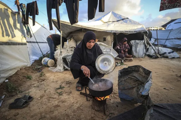 فلسطينية تعدّ وجبة الإفطار خلال شهر رمضان في مخيم النصيرات للاجئين شمال دير البلح (أ.ف.ب)