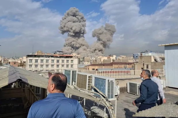 People watch as smoke rises on the skyline after an explosion in Tehran, Iran, Feb. 28, 2026. (AP)