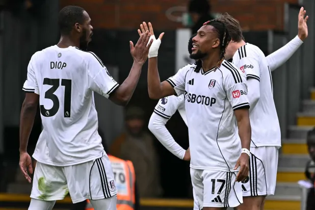 أليكس إيوبي نجم وسط فولهام «يمين» يتلقى تهنئية زميله ديوب (أ.ف.ب)