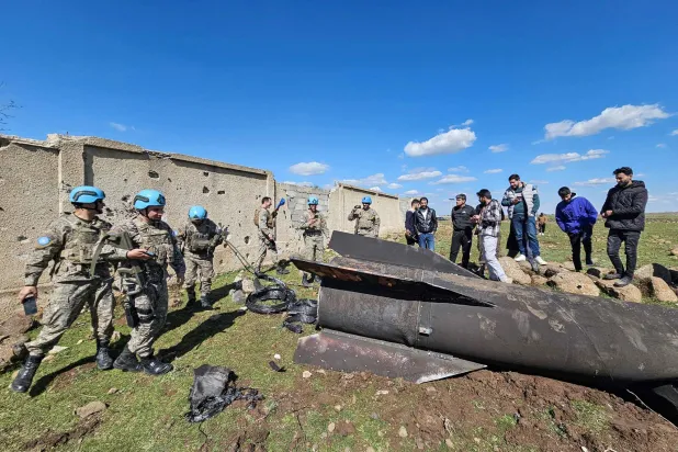 قوات حفظ السلام التابعة للأمم المتحدة ومدنيون قرب حطام صاروخ إيراني اعترضته القوات الإسرائيلية في ريف القنيطرة جنوب سوريا يوم 28 فبراير (أ.ف.ب)