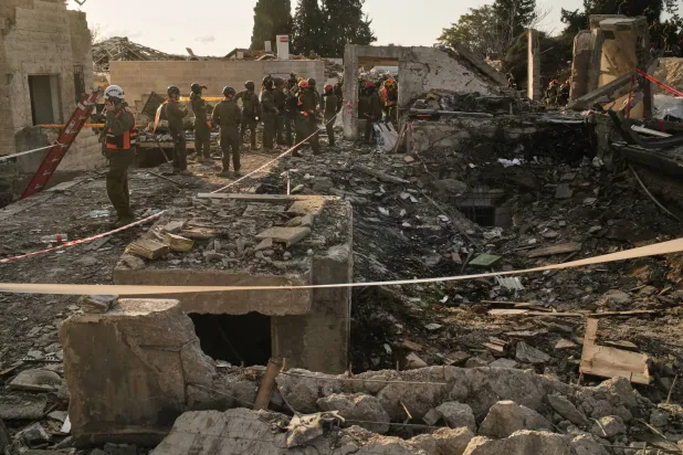 عمال إنقاذ في موقع صاروخ إيراني في بيت شيمش قرب القدس يوم الأحد (أ.ب)