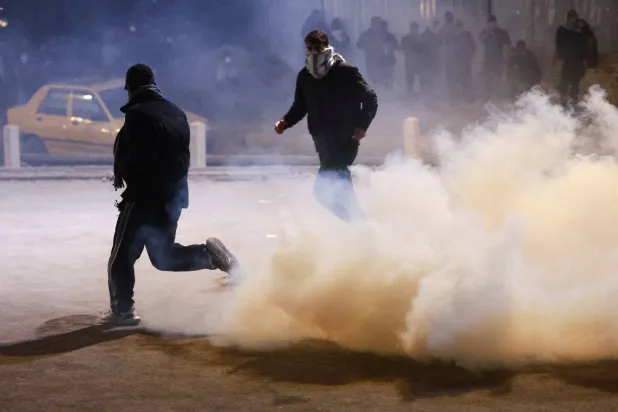 Demonstrators run amid tear gas as supporters of Iraqi Shiite armed groups attempt to move toward the US embassy located in Baghdad's Green Zone following the Israel and US strikes on Iran and the killing of Iran’s Supreme Leader Ali Khamenei, in Baghdad, Iraq, March 1, 2026. (Reuters)