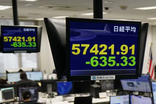 لوحات الأسهم الإلكترونية تعرض مؤشر «نيكي» الياباني في شركة وساطة لصرف العملات الأجنبية (أ.ب)