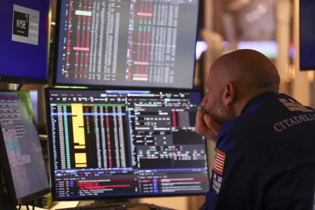 متداول يراقب شاشات تعرض مؤشرات الأسهم في بورصة نيويورك (إ.ب.أ)