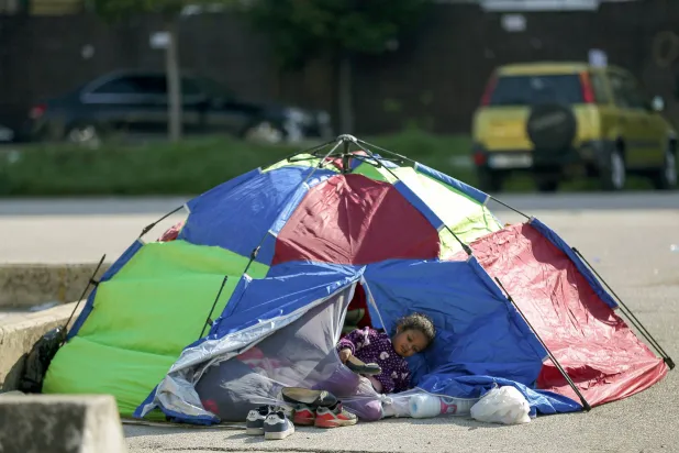 عائلة لبنانية تجلس في خيمة وسط بيروت بعد فرارها من منزلها في الضواحي الجنوبية للمدينة (د.ب.أ)