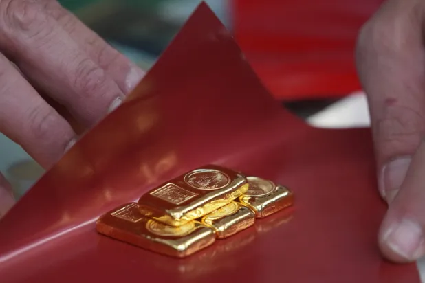 يشتري أحد الزبائن سبائك الذهب في متجر ببانكوك بتايلاند (أ.ب)