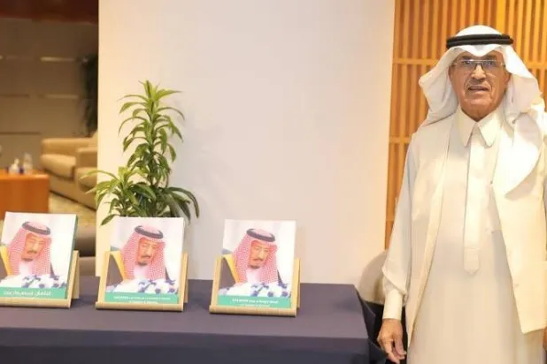 الدكتور إبراهيم المطرف بجانب كتابه «سلمان: قراءة في فكر ملك» في 3 إصدارات باللغات العربية والإنجليزية والفرنسية (الشرق الأوسط)