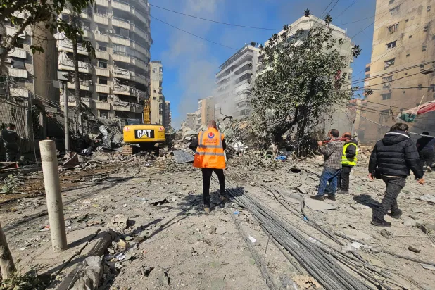 عناصر بالدفاع المدني يعملون على رفع الأنقاض من موقع غارة إسرائيلية في الضاحية الجنوبية لبيروت (أ.ب)