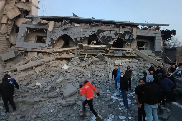 Rescue workers gather in front of the destroyed center of the Jamaa Islamiya group which hit by an Israeli strike, in the southern port city of Sidon, Lebanon, Tuesday, March, 3, 2026. (AP) 