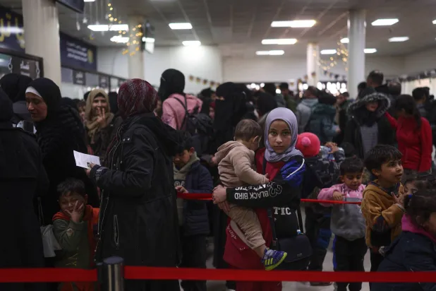 Syrians who fled the war in Lebanon check in after arriving at the Syrian-Lebanese border crossing in Jdeidet Yabous, Syria, Tuesday, March 3, 2026. (AP Photo/Ghaith Alsayed)
