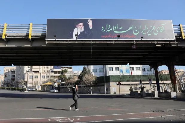 إيرانية تمر أمام لوحة إعلانية للمرشد علي خامنئي في أحد شوارع طهران(رويترز)
