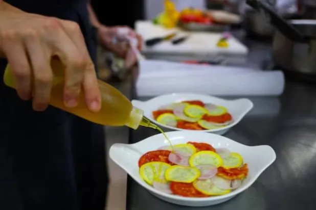 طباخ يحضر الأطباق في مطعم باريسي (رويترز)