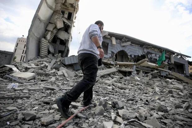 أحد السكان يتفقد ركام مبنى «الجماعة الإسلامية» الذي دمرته إسرائيل في مدينة صيدا الثلاثاء (إ.ب.أ)