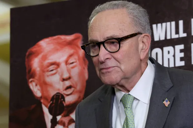 زعيم الديمقراطيين تشاك شومر يتحدث ووراءه صورة ترمب في الكونغرس في 3 مارس 2025 (أ.ف.ب)