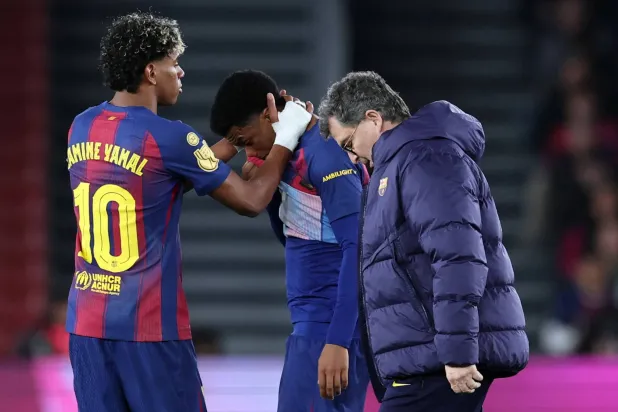 لامين جمال يواسي أليخاندرو بالدي أثناء خروجه من الملعب بعد تعرضه لإصابة خلال مباراة إياب نصف نهائي كأس ملك إسبانيا أمام أتلتيكو مدريد (أ.ف.ب)