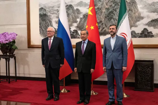 Russian Deputy Foreign Minister Sergei Ryabkov, Chinese Foreign Minister Wang Yi and Iranian Deputy Foreign Minister Kazem Gharibabadi pose for a photo as they meet on March 14, 2025 in Beijing, China. Pool via REUTERS 
