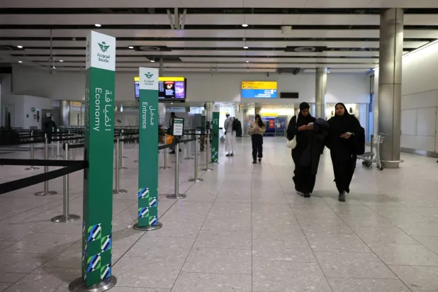 مسافرون يمرون بمنطقة تسجيل الركاب التابعة لـ«الخطوط السعودية» في مطار هيثرو (رويترز)