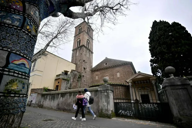 Pedestrians walk past the Basilica of Santa Agnese Outside the Walls as a marble bust is displayed inside after being identified as a work by Michelangelo Buonarroti after centuries without attribution, following a decade of archival research by Italian researcher Valentina Salerno in Rome on March 4, 2026. (AFP)