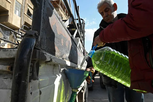 رجل يعبئ سيارته بالوقود في محطة بنزين بدمشق كإجراء احترازي وسط الحرب الدائرة في الشرق الأوسط (إ.ف.ب)