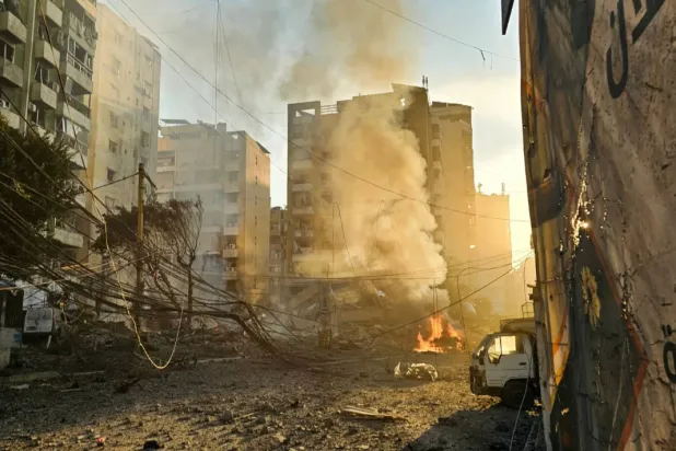 Fires erupt from buildings damaged in an early morning Israeli strike on Beirut's southern suburbs on March 3, 2026. (Photo by AFP)
