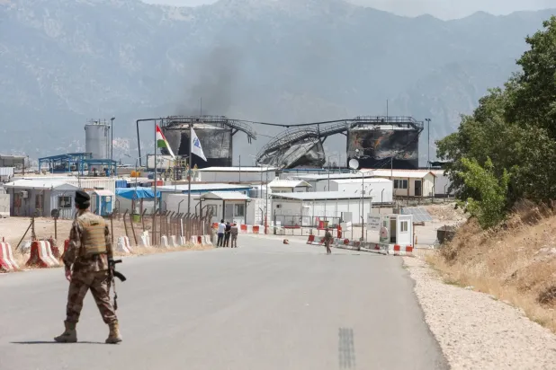 Irak'ın Dohuk vilayetinde İHA saldırısının ardından petrol sahası yakınında duran bir güvenlik görevlisi (Arşiv- Reuters)