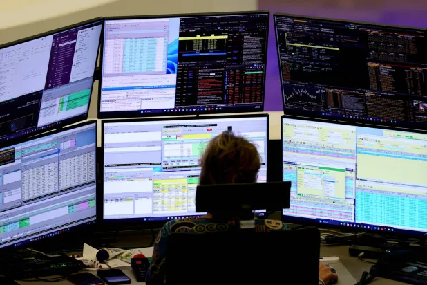 وسيط يراقب نشاط الأسهم بمكتبه في بورصة فرانكفورت (إ.ب.أ)