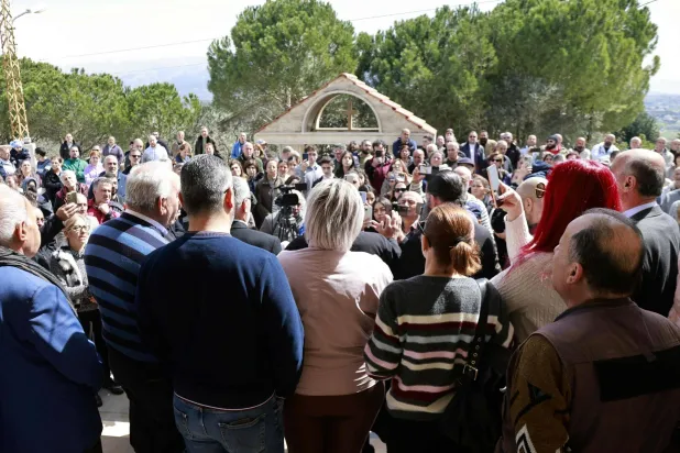 Residents of the southern Lebanese border town of Marjeyoun gather to listen to their priest in the town's churchyard to assert their intention not to leave their homes as directed by the Israeli military earlier this week on March 6, 2026. (AFP)