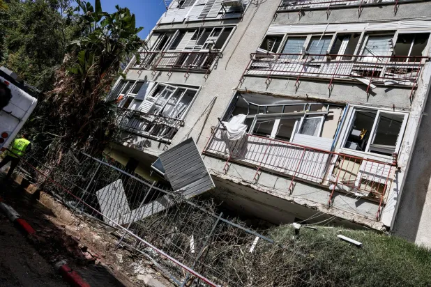 مبنى متضرر من القصف بإحدى ضواحي تل أبيب (رويترز)