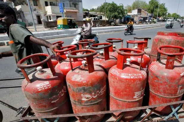 رجل يدفع عربة محملة بأسطوانات غاز الطهي في مدينة أحمد آباد غرب الهند (رويترز)