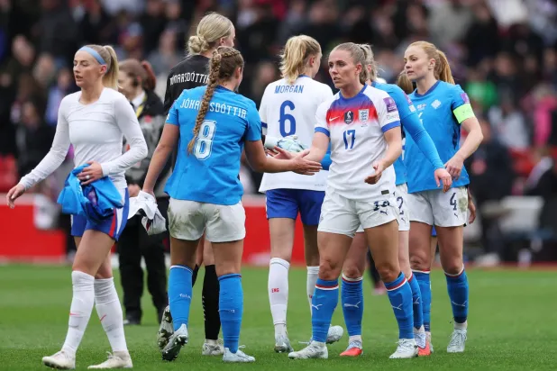 سيدات إنجلترا يصافحن نظيراتهن الآيسلنديات بعد مباراة تصفيات المونديال (رويترز)