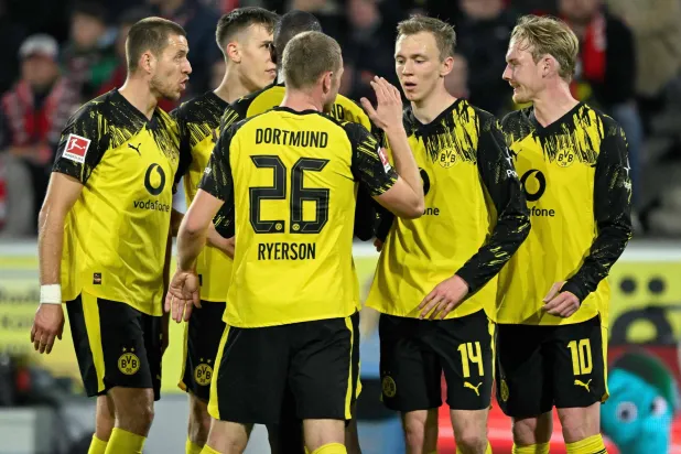 لاعبو دورتموند يحتفلون بالهدف الأول في المباراة (أ.ف.ب)
