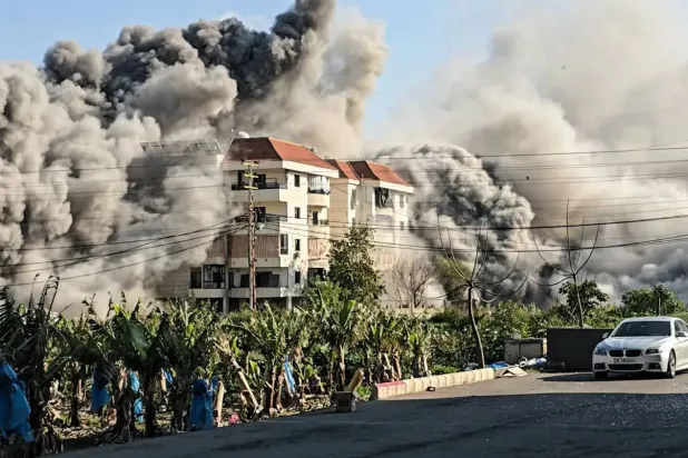 İsrail'in Lübnan'ın güneyindeki Tire kentinde, bölge sakinlerine tahliye uyarısı yaptıktan sonra hedef aldığı binalardan duman yükseliyor, (AFP)