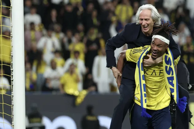 خيسوس محتفلا مع لاعبه سيماكان بعد الفوز (تصوير: عبدالعزيز النومان)